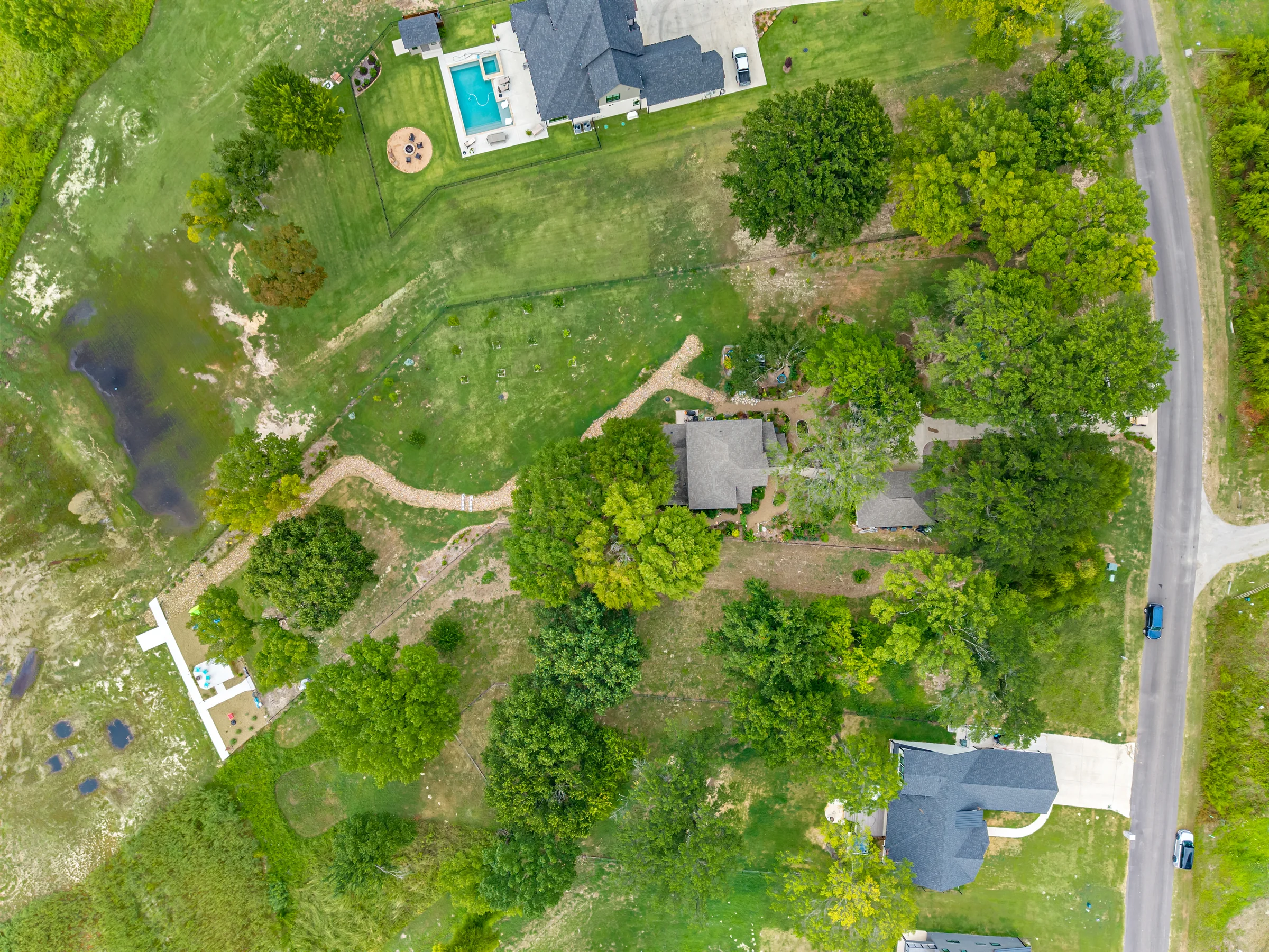 Top-down aerial showing the waterfront home, gardens and grounds